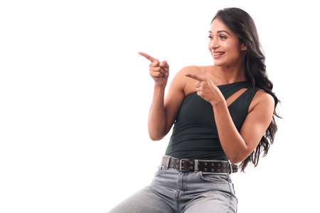 Portrait of a beautiful young asian woman pointing at something isolated on white backgroundの写真素材