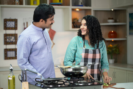 Indian couple cooking together in the kitchen at home. Indoors.の写真素材