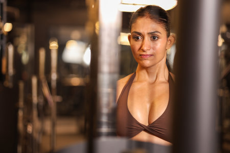 Portrait of young latin woman in bikini looking at camera in gymの写真素材