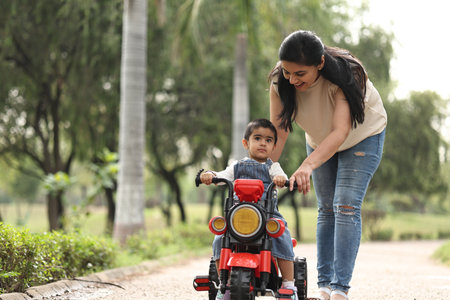 Mother and son ride a bike in the park. Happy family concept.の写真素材