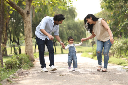 Happy family walking in the park. Mother, father and their daughter.の写真素材