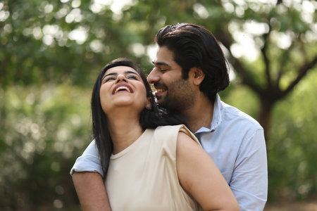 Happy Indian couple embracing each other in the park, low angle viewの写真素材