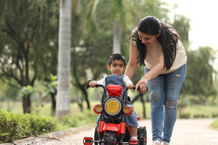 Mother and son riding motorcycle in the park. Happy family concept.