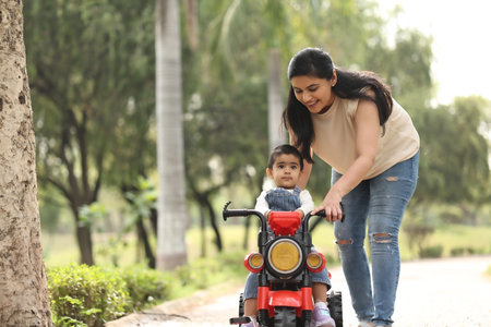 Mother and daughter riding a motorbike in the park. Family travel concept.の写真素材