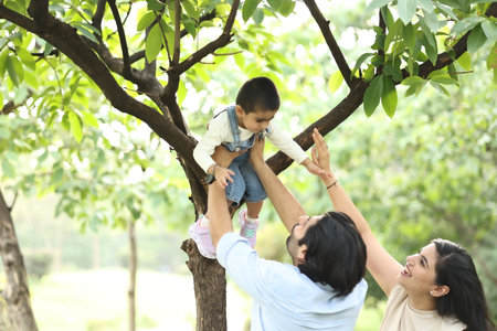 Happy asian family playing on tree in the park at summer.の写真素材