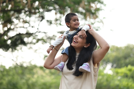 Mother and son playing in the park at the day time. Concept of friendly family.