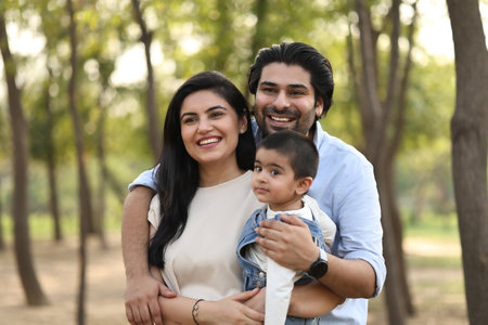 Happy Indian family with baby boy in park, focus on woman.の写真素材