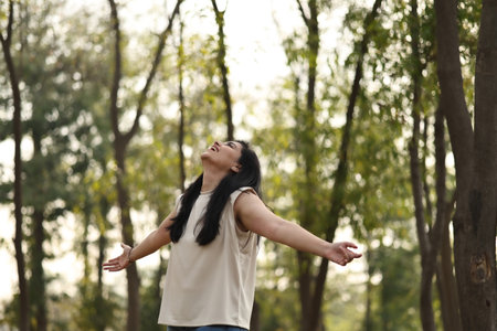 Happy young woman enjoying life in the park. Beautiful asian woman outdoor portrait.