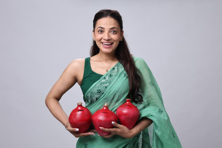 Young woman holding a red piggy bank on a grey background
