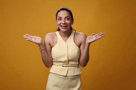 Portrait of a happy young businesswoman isolated over yellow background.の写真素材