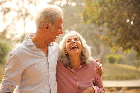 Happy senior couple walking in park on summer day, focus on woman