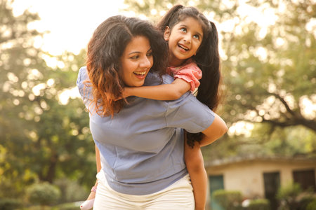 Portrait of happy mother and daughter playing in the garden at home