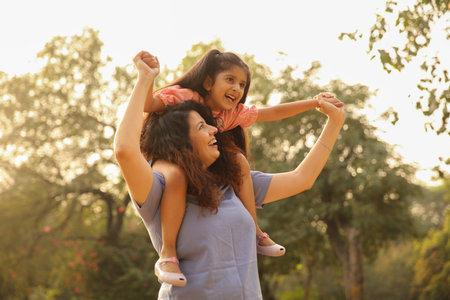 Mother and daughter having fun together in the park. Happy family concept.