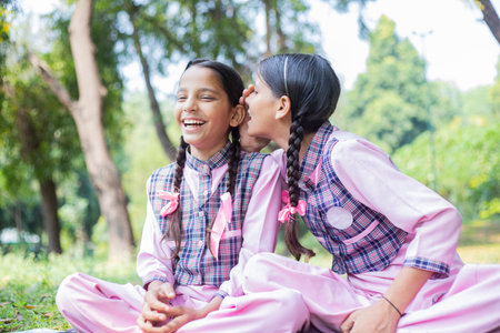 Portrait of two little girls sitting on the grass in the park