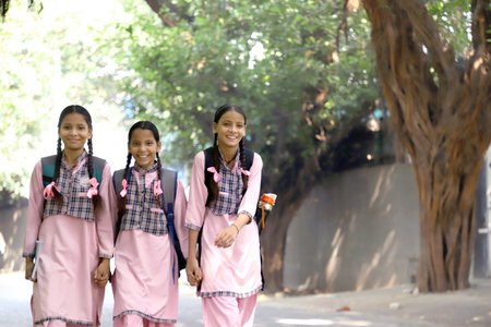Portrait of three young girls with backpacks in the park.の写真素材