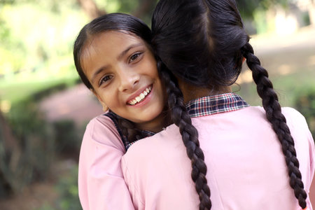 Portrait of a cute little girl hugging her mother in the parkの写真素材