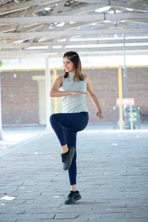 young beautiful and happy Asian Korean woman in sportswear stretching and warming up at modern city street in healthy lifestyle and fitness conceptの写真素材