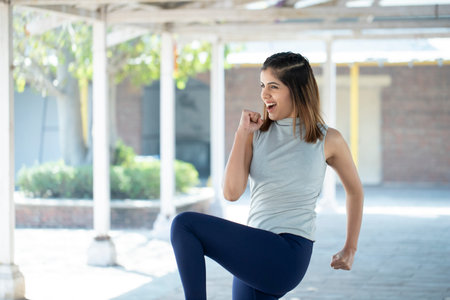Portrait of a happy young woman running outdoors in the city.の写真素材