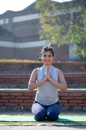 Portrait of a young woman doing yoga in the park on a sunny day