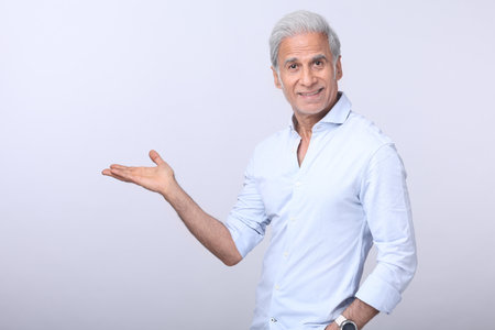 Portrait of a happy senior man holding something on a white background