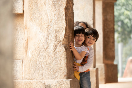 Little boy and girl standing near the wall of temple in India.の写真素材