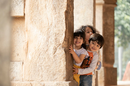 Portrait of happy kids looking at camera in front of ancient buildingの写真素材