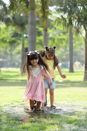Cute little girls playing in the park on a sunny day.の写真素材