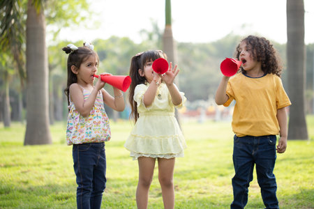 Group of cute asian children playing with megaphone in the parkの写真素材