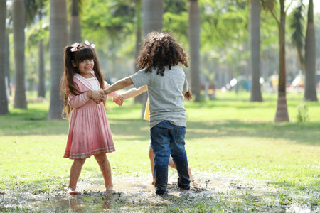 Cute little girl and boy playing together in the park. Happy childhood concept.の写真素材