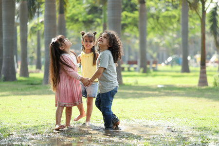 Happy children playing together in the park at summer day time.の写真素材