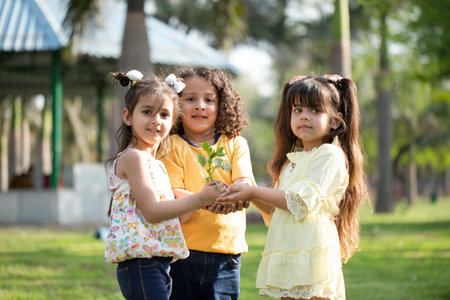 Portrait of cute little girls holding a flower in the park.の写真素材