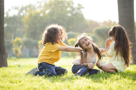 Little girls having fun together in the park on a sunny day.の写真素材