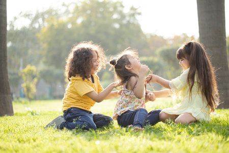 Three little girls playing together in the park. The concept of friendship and childhood.の写真素材
