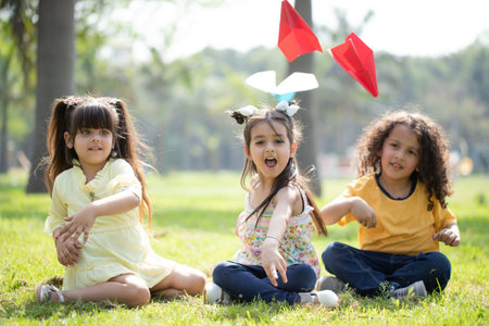 Group of children playing with paper airplane in the park. Happy and fun concept.の写真素材