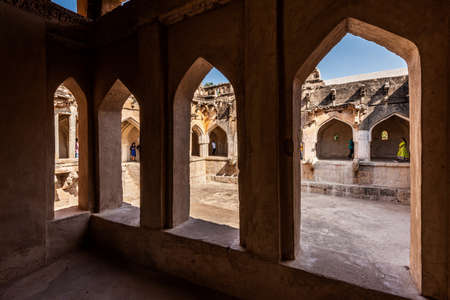 Hampi, Karnataka, India - January 14, 2020 : Queens bath structure of Vijayanagara Empire. 3 sides of the square dry pool with its walls, corridors and halls in brown stone. Hampi, Karnataka, India.のeditorial素材