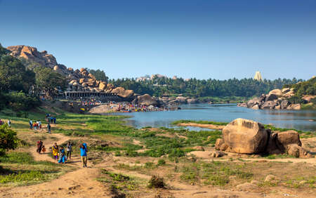 Hampi, Karnataka, India - January 10, 2020 : People bathing and getting ready on the banks of river Tungabhadra in Hampi Town.のeditorial素材
