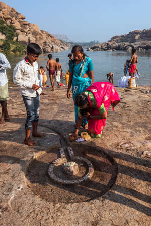 Hampi, Karnataka, India - January 10, 2020 : People bathing and getting ready on the banks of river Tungabhadra in Hampi Town.のeditorial素材