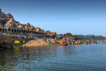 Hampi, Karnataka, India - January 10, 2020 : People bathing and getting ready on the banks of river Tungabhadra in Hampi Town.のeditorial素材
