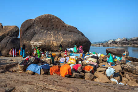Hampi, Karnataka, India - January 10, 2020 : People bathing and getting ready on the banks of river Tungabhadra in Hampi Town.のeditorial素材