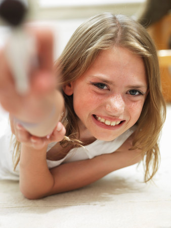 Girl smiling lying on her tummyの写真素材