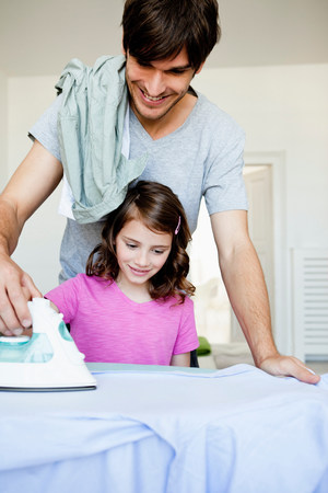Father and girl ironingの写真素材