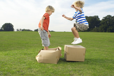 Two boys jumping on boxesの写真素材