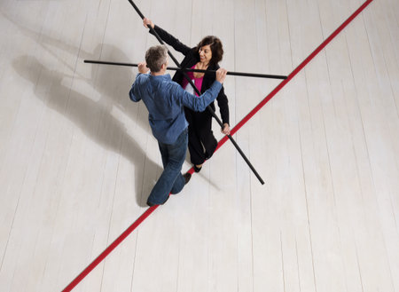 Man and woman balancing on thin red lineの写真素材