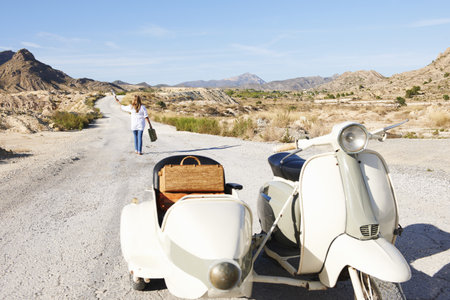 Woman walking away from motorbike
