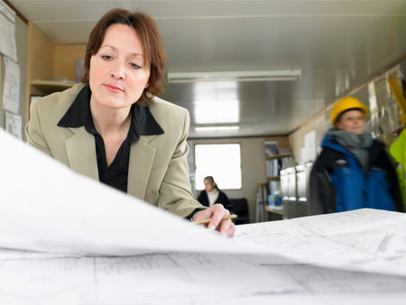 Businesswoman examining blueprintsの写真素材