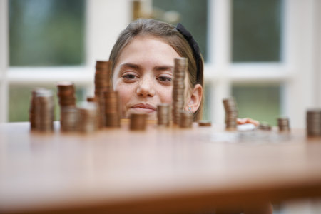 Girl looking at piles of moneyの写真素材