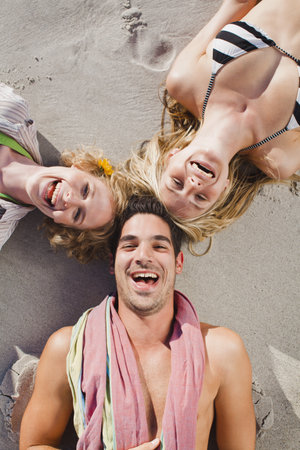 People lying in formation on beachの写真素材