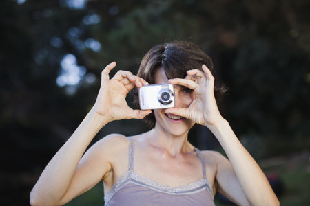 Woman taking a picture outdoorsの写真素材