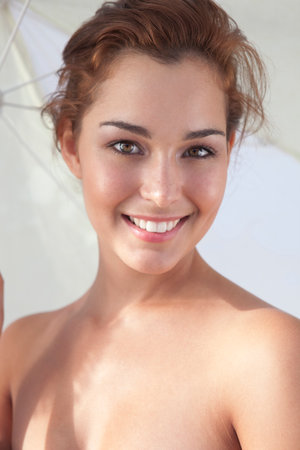 Smiling woman holding umbrellaの写真素材