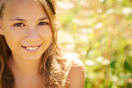 Teenage girl smiling in tall grassの写真素材